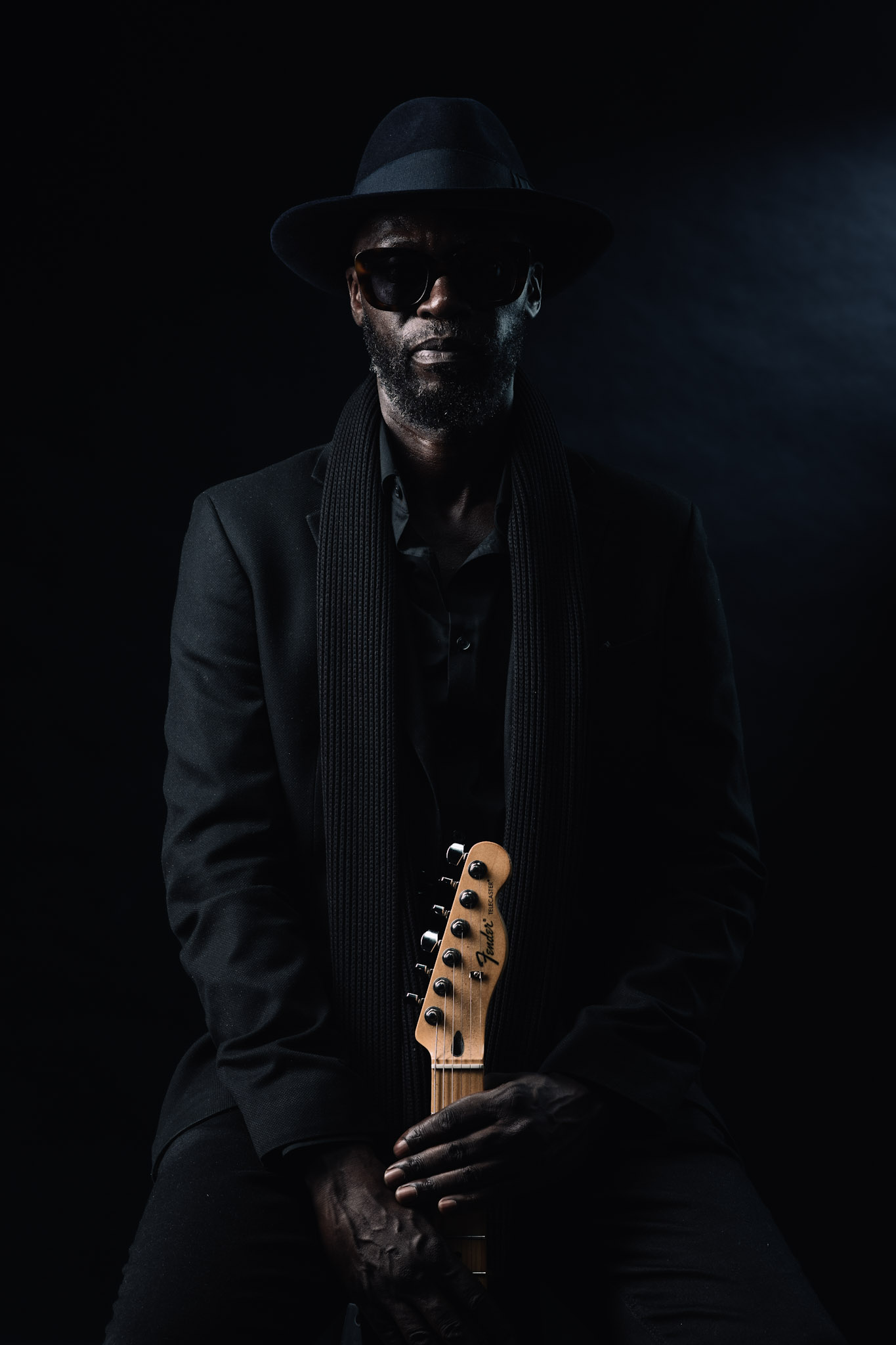Kyazi Lugangira in sunglasses with a Fender Telecaster headstock in frame
